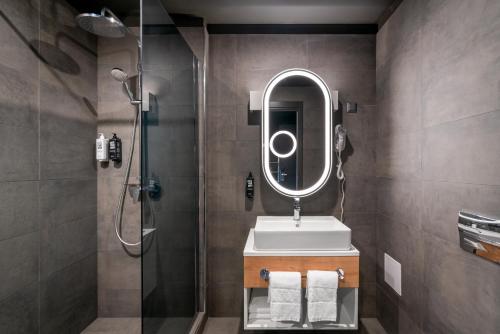 a bathroom with a sink and a shower with a mirror at ibis Bucharest Politehnica in Bucharest
