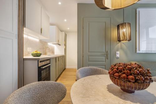 une cuisine avec une table avec un bol de fruits dessus dans l'établissement Lordino, à Paris