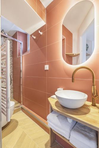 une salle de bain avec un lavabo et un miroir dans l'établissement Lordino, à Paris