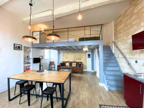 un salon avec une table à manger et une mezzanine dans l'établissement Le Balthazar Beau T1 mezzanine, centre historique, à Montpellier
