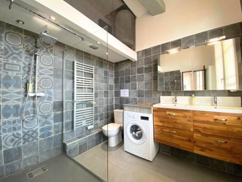 une salle de bain avec une machine à laver et un lave-linge dans l'établissement Le Balthazar Beau T1 mezzanine, centre historique, à Montpellier