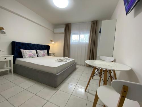a bedroom with a bed and a table and chairs at Sunny Beach Potos in Potos
