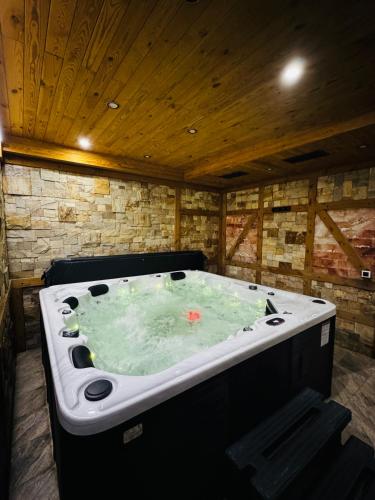 a jacuzzi tub in a room with a wooden ceiling at KABAN BOUTIQUE HOTEL - 5Star Central Villa in Vatra Dornei in Vatra Dornei