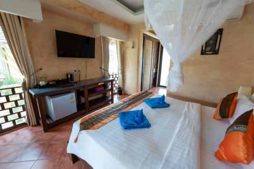 a bedroom with a bed and a tv in a room at Wind Beach Resort in Koh Tao