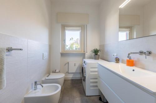 a white bathroom with a sink and a toilet at Blue Dream in Ispra