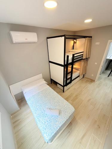 a room with two beds and a bunk bed at Hostel VAM Torrejón in Torrejón de Ardoz