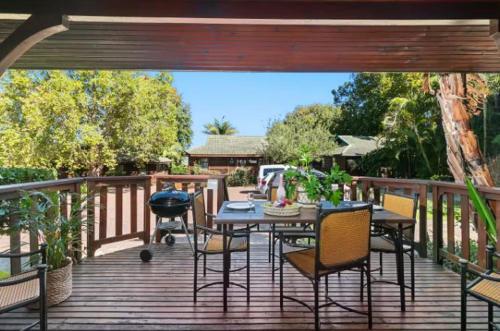 a patio with a table and chairs on a deck at Knysna River Club Getaways - Luxury waterfront chalets in Knysna