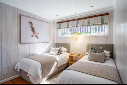 a bedroom with two beds and a window at Knysna River Club Getaways - Luxury waterfront chalets in Knysna