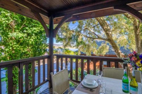 a table and chairs on a porch with a view of the water at Knysna River Club Getaways - Luxury waterfront chalets in Knysna