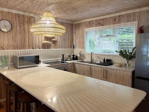 a kitchen with a large white counter top and a clock at Knysna River Club Getaways - Luxury waterfront chalets in Knysna