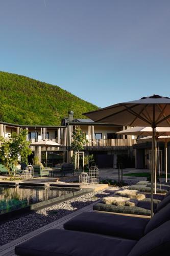 a building with an umbrella next to a pool at Agrad Chalets in Aschau im Chiemgau