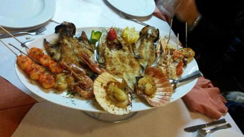 a plate of food with seafood on a table at Hotel Diplomat Palace in Rimini