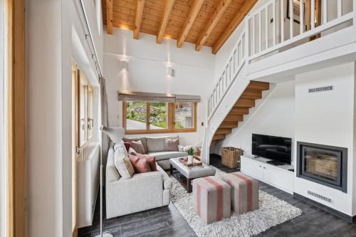 a living room with a couch and a fireplace at Duplex Piste Rouge by Miggins in Grimentz
