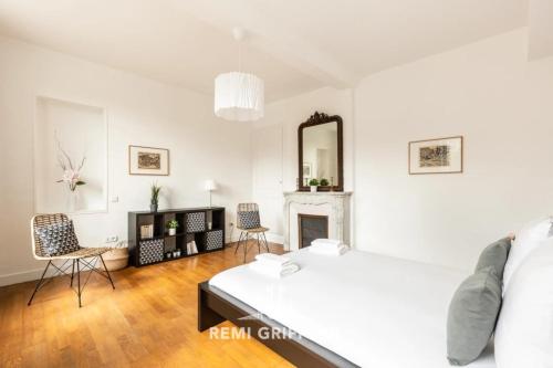 a white bedroom with a bed and a fireplace at Hypolite 1 Cosy Apartment 80 meters from the Port of Honfleur 2 guest in Honfleur
