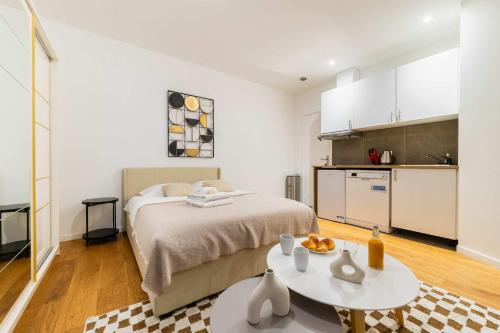 une chambre avec un lit et une table et une cuisine dans l'établissement Studio agreable et bien placee - Paris 18 - 2P, à Paris