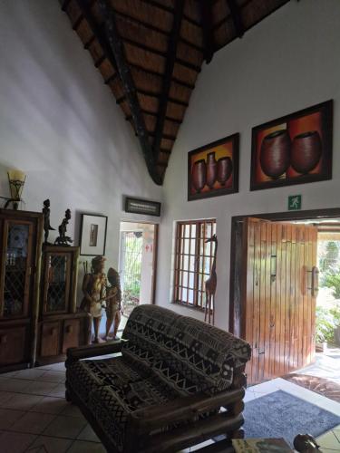 a living room with a couch in the middle of a room at African Ambience Guest House in St Lucia