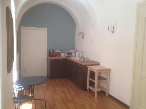 eine Küche mit einer Spüle, einem Tisch und einer Theke in der Unterkunft Lo Studio di Joyce in Triest