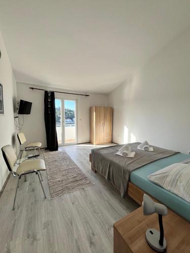 a bedroom with a bed and a table and a chair at Apartments Peronja Jelsa Seafront in Jelsa
