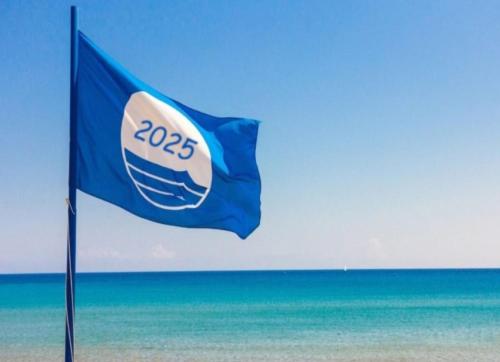 a blue flag on the beach with the ocean in the background at Casa Vacanze Formia in Formia