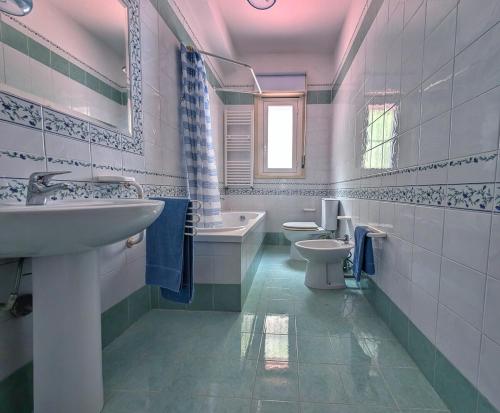 a bathroom with two toilets and a sink and a tub at Casa del Mandorlo in Plemmirio