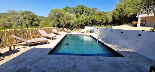 - une piscine dans un jardin avec des chaises longues dans l'établissement Villa moderne avec piscine 4 étoiles, à Sotta