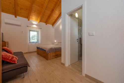 a bedroom with a bed and a couch in a room at Apartment Varos with shared pool in Ugljan