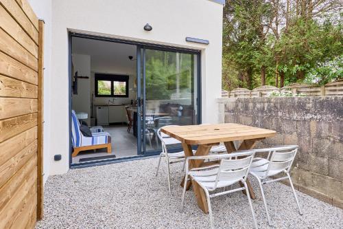 un patio avec une table et des chaises en bois dans l'établissement Margaux - Proche du Port, à Barneville-Carteret