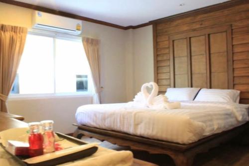 a bedroom with a bed with a swan on it at เคียงตะวัน รีสอร์ท in Ban Yang