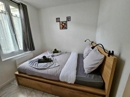 - une chambre avec un lit avec deux chats assis dans l'établissement Au Fil de la Marne à 15mn Disney et 25mn Paris, à Lagny-sur-Marne