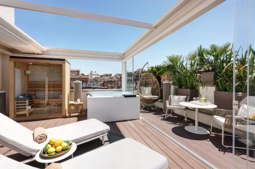 an outdoor patio with a table and chairs on a balcony at The First Arte - Preferred Hotels & Resorts in Rome