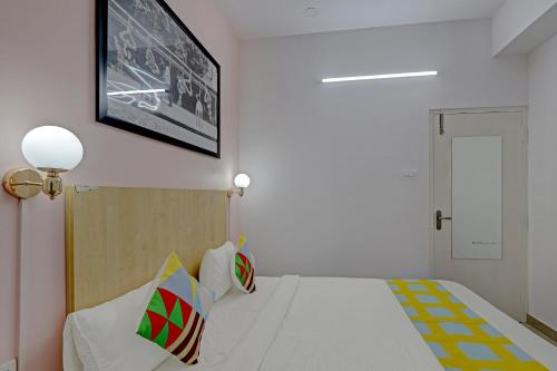 a bedroom with a bed with a tv on the wall at Hotel O Compact Studio Kr Puram Near Phoenix Marketcity in Bengaluru