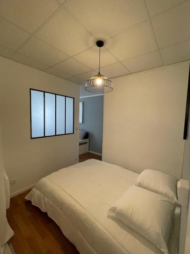 a bedroom with a white bed and a pendant light at Le Charme Provençal - Centre-ville - Calme in Digne-les-Bains