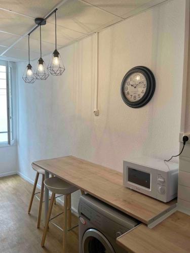 une cuisine avec une table et une horloge au mur dans l'établissement Le Charme Provençal - Centre-ville - Calme, à Digne-Les-Bains