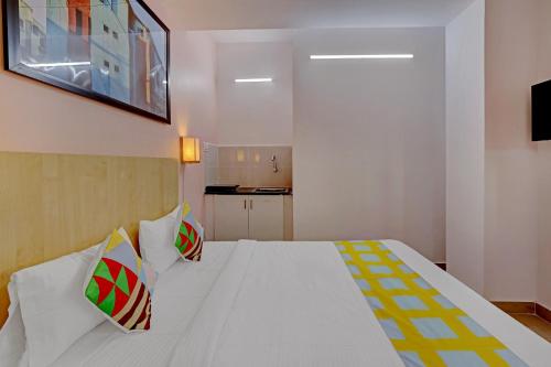 a bedroom with a large white bed with two pillows at Hotel O Compact Studio Kr Puram Near Phoenix Marketcity in Bengaluru