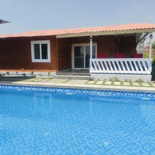 a swimming pool in front of a house at Kuku Farm Stay in Venkatāpur