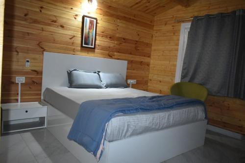 a bedroom with a bed in a wooden cabin at Kuku Farm Stay in Venkatāpur