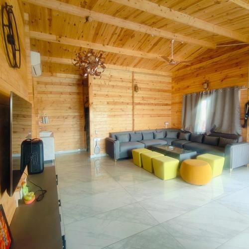 a large living room with a couch and a table at Kuku Farm Stay in Venkatāpur