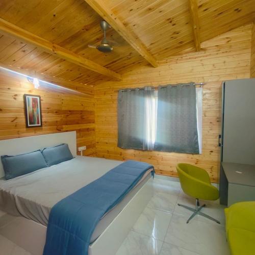 a bedroom with a bed and a chair in a room at Kuku Farm Stay in Venkatāpur