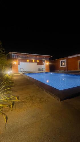 a large swimming pool at night with a building at Kuku Farm Stay in Venkatāpur