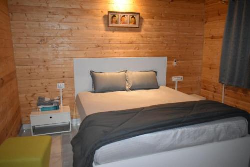 a bedroom with a bed with a wooden wall at Kuku Farm Stay in Venkatāpur