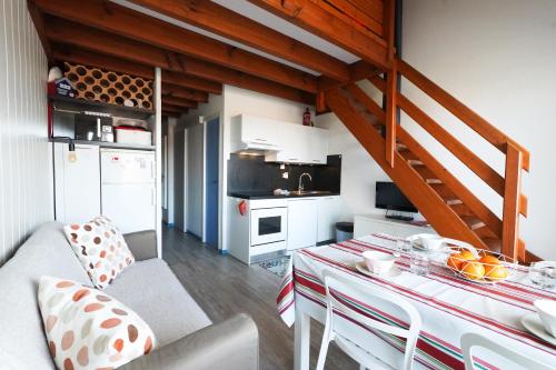 un salon avec une table et une cuisine dans l'établissement Appartement en duplex 2* Résidence Les Pêcheurs, à Biscarrosse