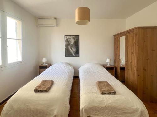une chambre avec deux lits avec des serviettes dessus dans l'établissement Appartement 5 pièces Cannes, à Cannes