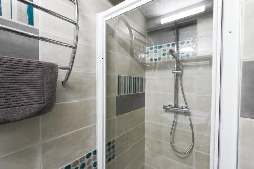 a shower with a glass door in a bathroom at Maisonnette au pied de l'Océan avec terrasse in Biscarrosse