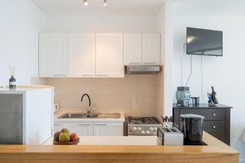 a kitchen with white cabinets and a bowl of fruit on a counter at Prizba Tomas 1 in Blato