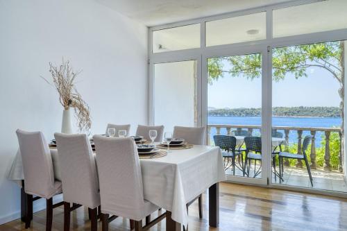 a dining room with a table and chairs and a large window at Prizba Tomas 1 in Blato