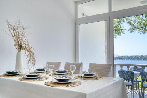 a white table with plates and wine glasses on it at Prizba Tomas 1 in Blato