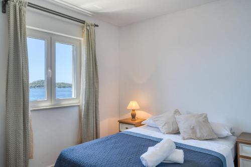 a bedroom with a blue bed and a window at Prizba Tomas 1 in Blato