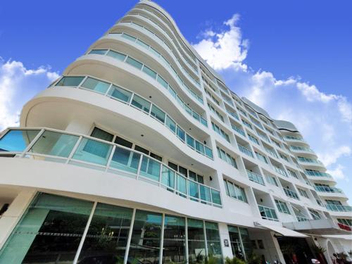 a large white building with a lot of windows at Nova Suites Pattaya by Compass Hospitality in Pattaya