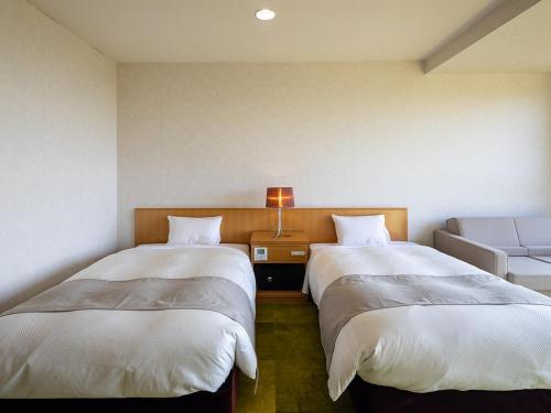 a room with two beds and a couch at Ooedo Onsen Monogatari Amakusa Hotel Kameya in Kami Amakusa