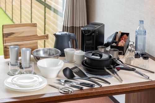 a table with plates and utensils on it at KAMENOI HOTEL Kujukuri in Asahi